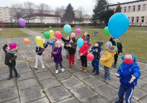 Dzieci wypuszczają balony w przestrzeń.
